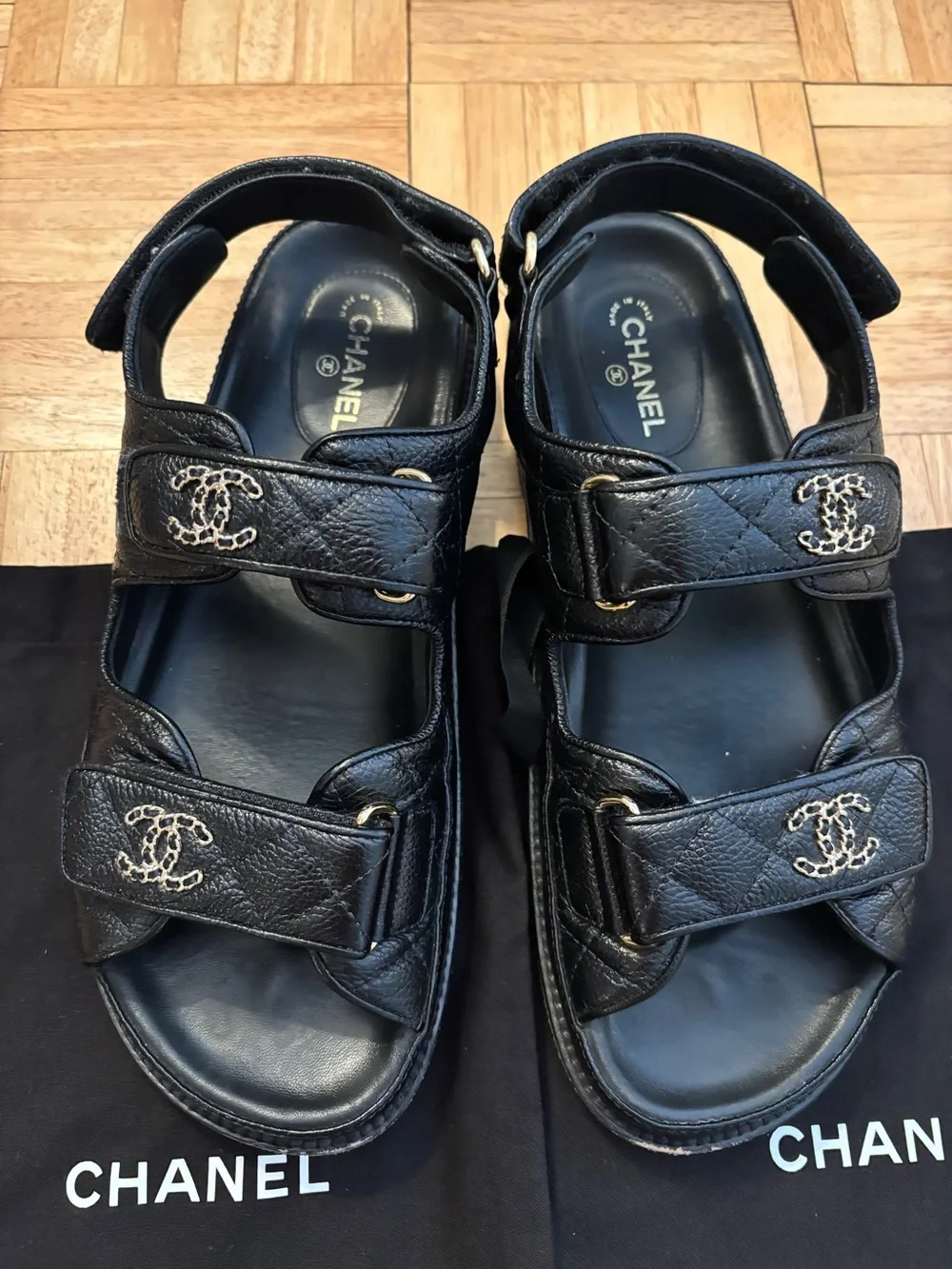 CHANEL Dad Black Leather Logo Strap Sandals with Gold CC Hardware.